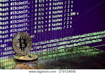 The digital process of cryptocurrency mining by using the GPUs. Bitcoins and video card on a working display and mining screen
