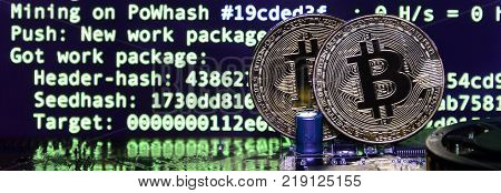 The digital process of cryptocurrency mining by using the GPUs. Bitcoins and video card on a working display and mining screen
