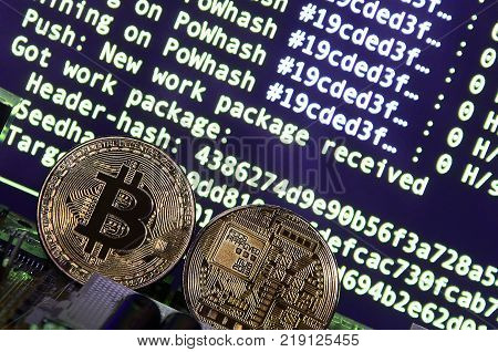 The digital process of cryptocurrency mining by using the GPUs. Bitcoins and video card on a working display and mining screen