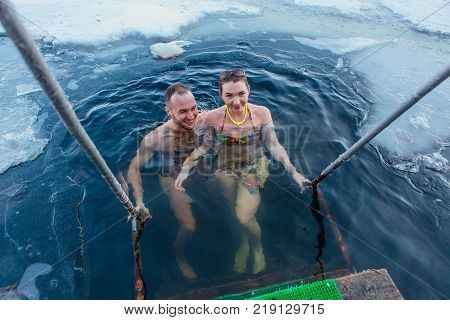 Novokuznetsk, Kemerovo region, Russia - 23 Feb, 2017 : White beaches of Siberia is an enterteiment activity where people playing beach games dressed in bikini in winter. Couple in ice hole