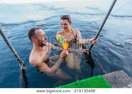 Novokuznetsk, Kemerovo region, Russia - 23 Feb, 2017 : White beaches of Siberia is an enterteiment activity where people playing beach games dressed in bikini in winter. Couple in ice hole