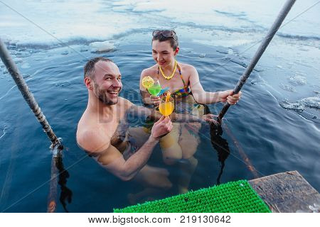 Novokuznetsk, Kemerovo region, Russia - 23 Feb, 2017 : White beaches of Siberia is an enterteiment activity where people playing beach games dressed in bikini in winter. Couple in ice hole