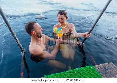 Novokuznetsk, Kemerovo region, Russia - 23 Feb, 2017 : White beaches of Siberia is an enterteiment activity where people playing beach games dressed in bikini in winter. Couple in ice hole