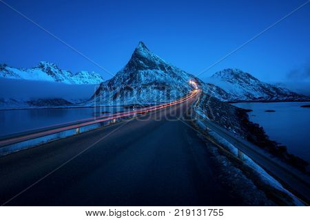 Olstind Mount and car light. Lofoten islands, spring time, Norway