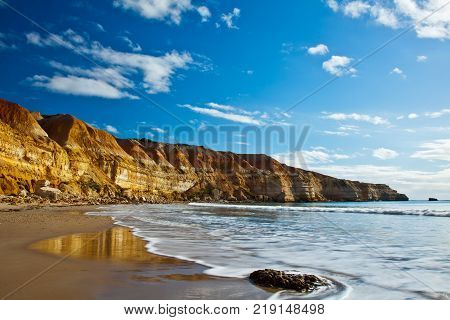 The amazing Maslins Beach limestone cliff with blue sky above