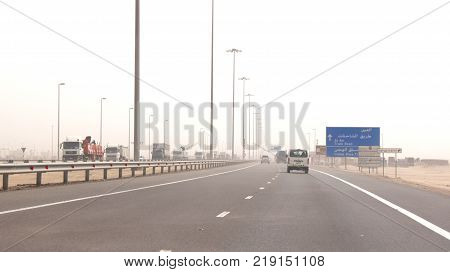ABU DHABI, UNITED ARAB EMIRATES - APRIL 3rd, 2014: Trucks driving on a desert motorway in the United Arab Emirates with heat haze.