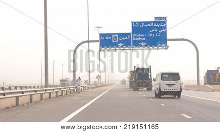 ABU DHABI, UNITED ARAB EMIRATES - APRIL 3rd, 2014: Trucks driving on a desert motorway in the United Arab Emirates with heat haze.