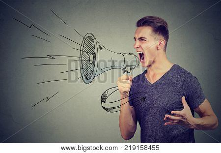 Young man screaming into a megaphone making an announcement