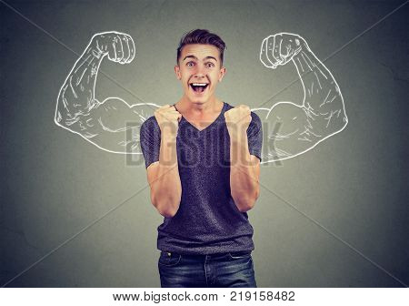 Successful man winning fists pumped celebrating success flexing muscles isolated on gray wall background. Positive human emotion facial expression. Life perception
