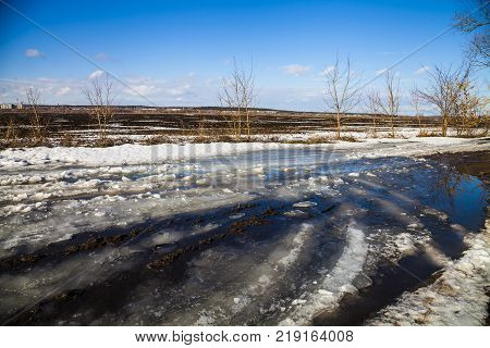 Beautiful spring landscape. Country road near the forest and fields in a sunny spring day.Snowbreak.