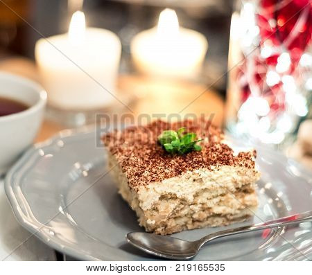 Tiramisu, traditional Italian dessert on a white plate