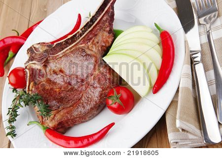 cibo di carne: manzo alla griglia di ricambio rib su piatto bianco con pepe timo e pomodoro sul tavolo di legno