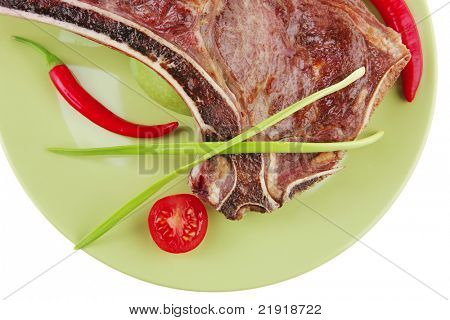 cibo di carne: manzo alla griglia di ricambio rib sul piatto verde con timo pepe e pomodoro isolato sopra ba bianco