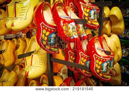 Dutch wooden shoes in the souvenir shop. Red and yellow Clog and Klomp in the storefront. Wooden klompen.