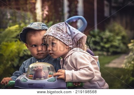 Cute charming baby girl with boy playing together in park symbolizing love and togetherness