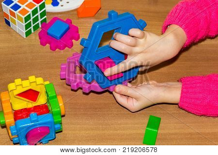 Closeup Of Child's Hand Taking Bright Mosaic Parts. Learning Colors At Home. Toddler Boy In A Stripe