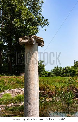 Ionic order column chapiter against blue sky in ancient ruins in Dion, Greece