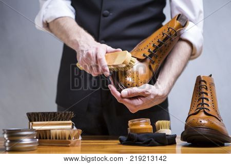 Footwear Concepts. Closeup of Mans Hands Cleaning Luxury Calf Leather Brogues with Special Accessories And Tools. Horizontal Composirion