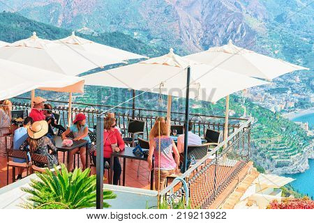 Ravello Italy - October 2 2017: People at Open air street cafe with umbrellas at Ravello village Tyrrhenian sea Amalfi coast Italy
