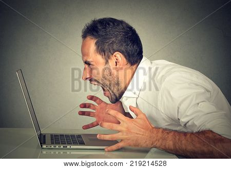 Angry furious business man screaming at computer. Negative human emotions facial expressions feelings aggression anger management issues concept