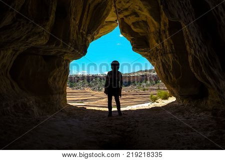 Woman Caver Spelunker exploring inside of a Dark Cave