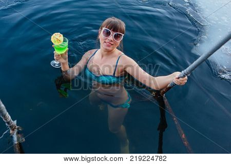 Novokuznetsk, Kemerovo region, Russia - 23 Feb, 2017 : White beaches of Siberia is an enterteiment activity where people playing beach games dressed in bikini in winter. Woman in an ice hole