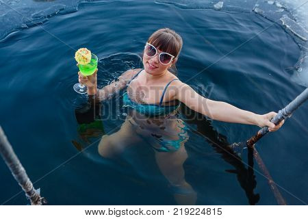 Novokuznetsk, Kemerovo region, Russia - 23 Feb, 2017 : White beaches of Siberia is an enterteiment activity where people playing beach games dressed in bikini in winter. Woman in an ice hole