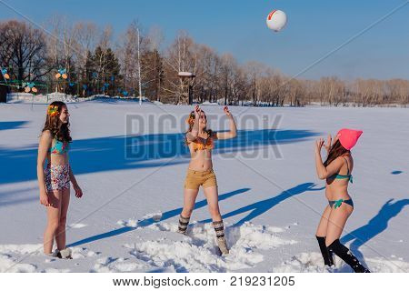 Novokuznetsk, Kemerovo region, Russia-23 Feb, 2017: White beaches of Siberia is an enterteiment activity where people playing beach games dressed in bikini in winter. Women playing volleyball on snow