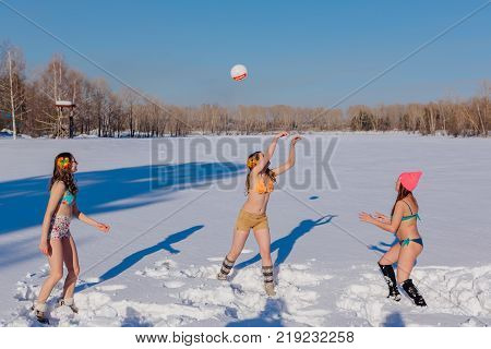 Novokuznetsk, Kemerovo region, Russia-23 Feb, 2017: White beaches of Siberia is an enterteiment activity where people playing beach games dressed in bikini in winter. Women playing volleyball on snow