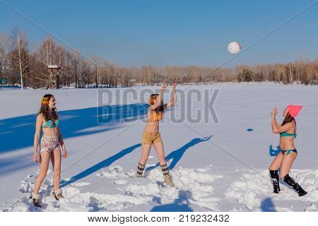 Novokuznetsk, Kemerovo region, Russia-23 Feb, 2017: White beaches of Siberia is an enterteiment activity where people playing beach games dressed in bikini in winter. Women playing volleyball on snow