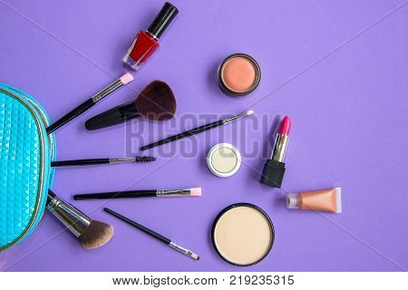 Makeup cosmetics tools background and beauty cosmetics products and facial cosmetics package lipstick eyeshadow on the purple background. Lifestyle Concept.