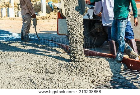 Builder Worker With From Truck Mounted Concrete Cement Into Formwork Reinforcement.