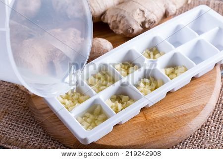 Frozen root of ginger with water. Freezing food.