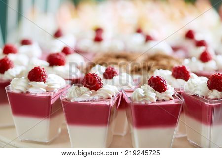 Set of delicious dessert : two-layer white and rose souffle, decorated with fresh raspberry and soft whipped cream for a rstaurant catering .