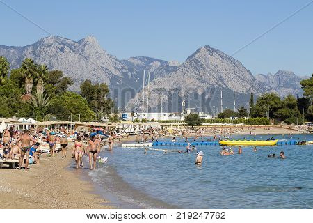 KEMER TURKEY - OCTOBER 18 2017 : People enjoying sun and sea at the turquoise sea and pebble beach. Kemer it is one of the most popular beach in Turkey