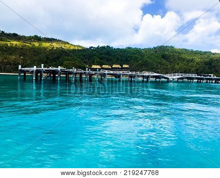 Crisp, clear, blue water beneath a pier that has been damaged by cyclone Debbie.