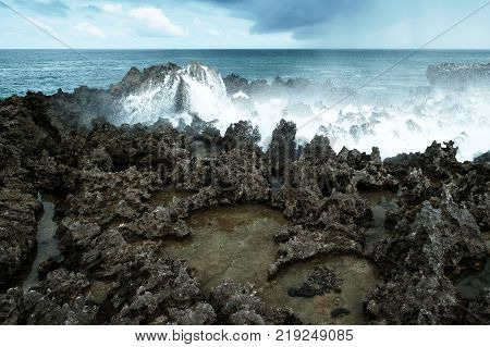 Waves break on rocky shore. Tourist beach resort in Nuca Dua of Bali