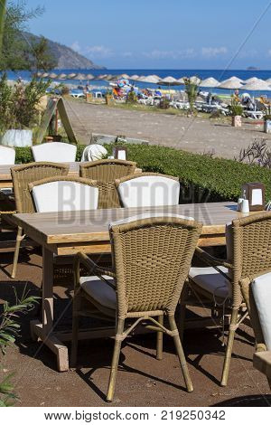 Table and chairs in empty cafe near the beach. Cirali Kemer Turkey. Close up