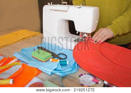 Woman hand on sewing machine. Dressmaker work on the sewing machine. Hobby sewing fabric as a small business concept. Female fashion designer working