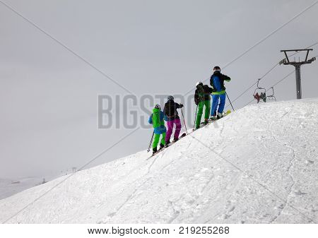 Skiers on snowy off-piste and overcast misty sky at day with bad weather. Caucasus Mountains in winter Georgia region Gudauri.