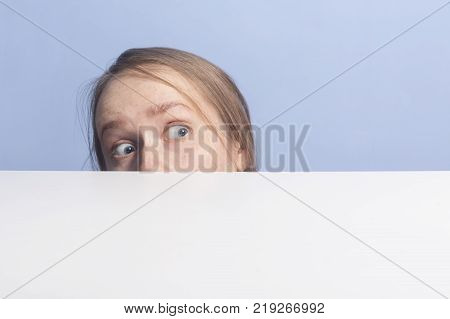 Top of female face behind white banner, isolated on blue background
