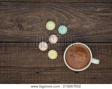 Freshly brewed cocoa and colorful bee on an old wooden table