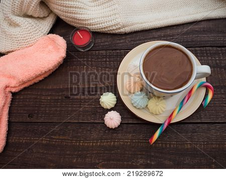 Freshly brewed cocoa and colorful biseza with candy on an old wooden table