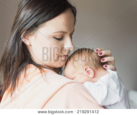 a young mother enjoys the first days of motherhood with her child holding it in her arms
