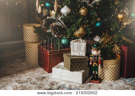 Decorated New Year tree and many presents under it. Christmas tree with many clolourful decorations. Idea for postcards. Christmas and New Year celebration. Holiday concept.