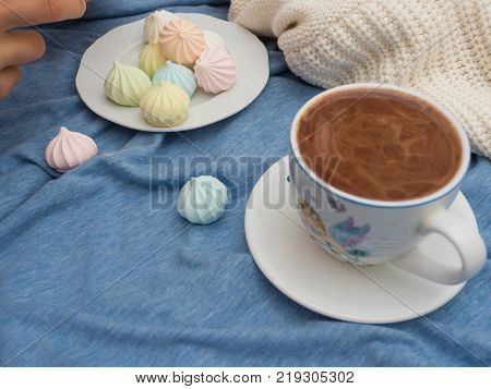 Freshly brewed cocoa with foam and colorful bise on the table
