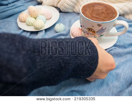 Freshly brewed cocoa with foam and colorful bise on the table