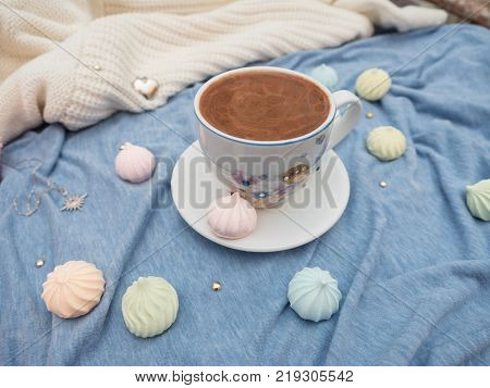 Freshly brewed cocoa with foam and colorful bise on the table