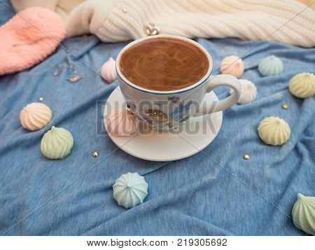 Freshly brewed cocoa with foam and colorful bise on the table