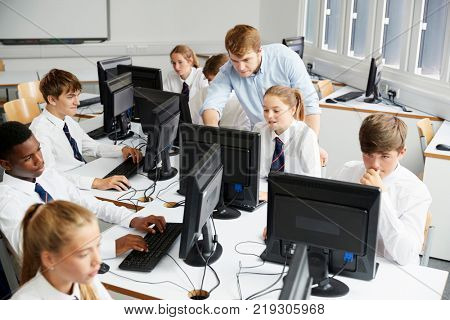 Teenage Students Wearing Uniform Studying In IT Class